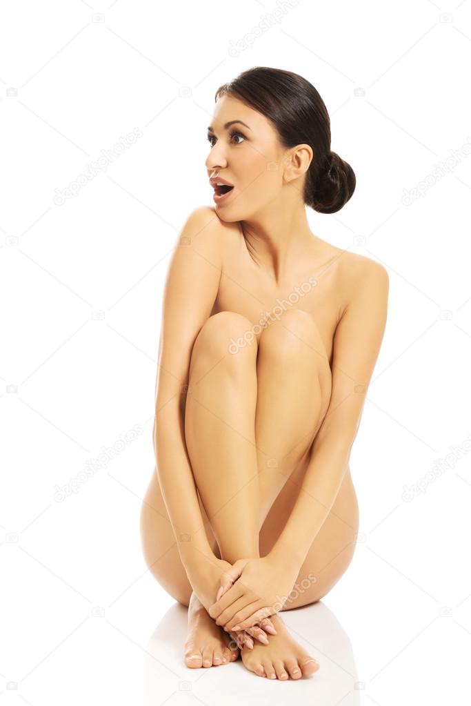 shocked nude woman sitting with bended